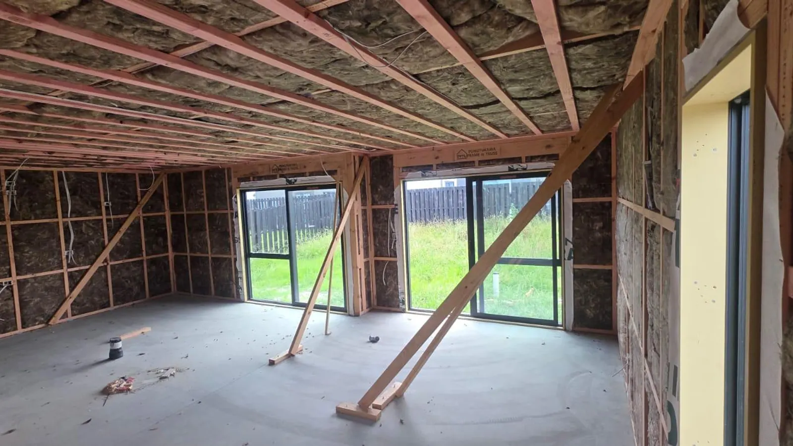 Earthwool mineral-wool insulation packed into a new-build roof and timber framing on an R-Value Insulation Co site in Auckland.