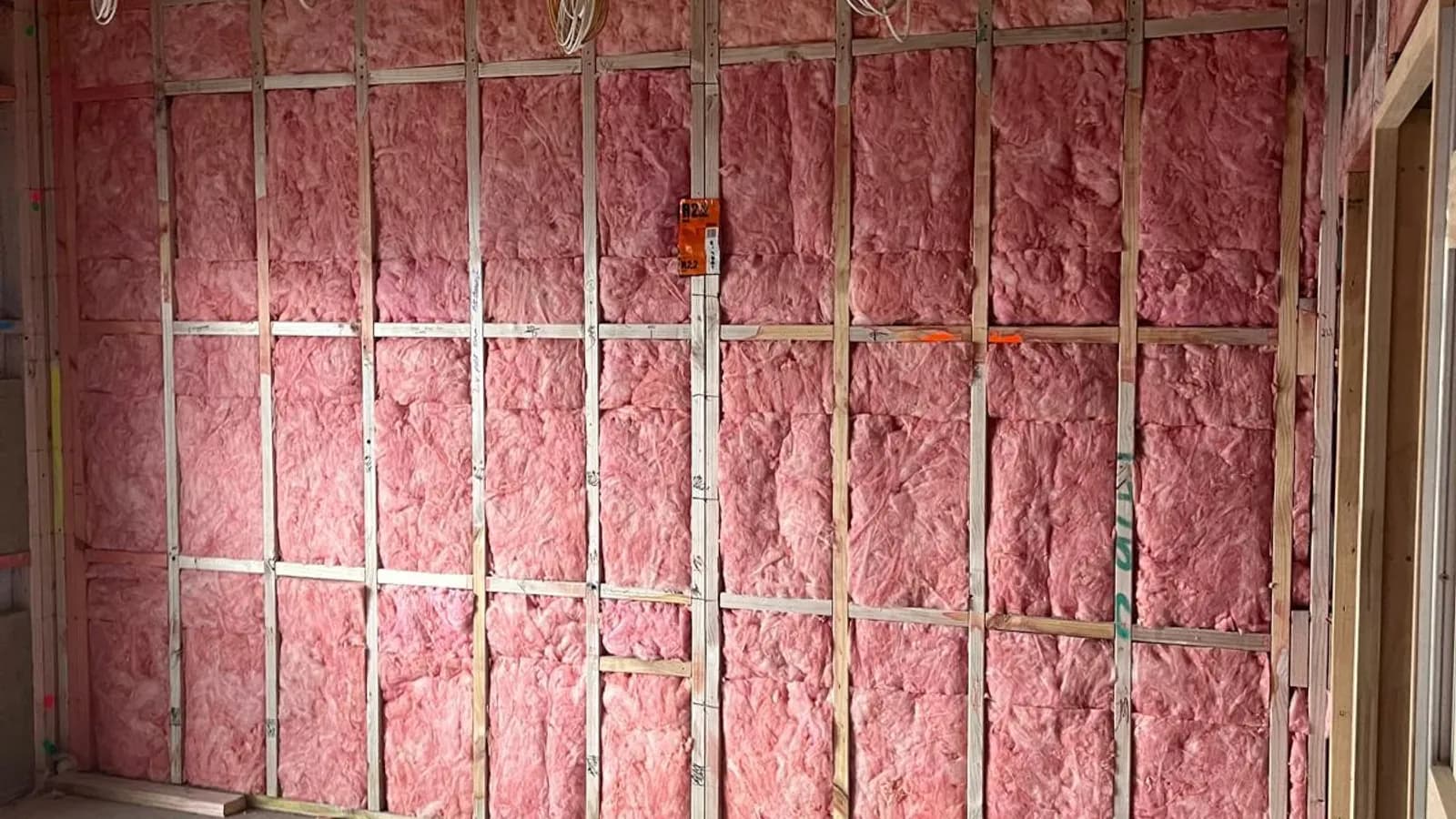 Pink Batts thermal insulation packed into stud framing on an R-Value Insulation Co commercial build.