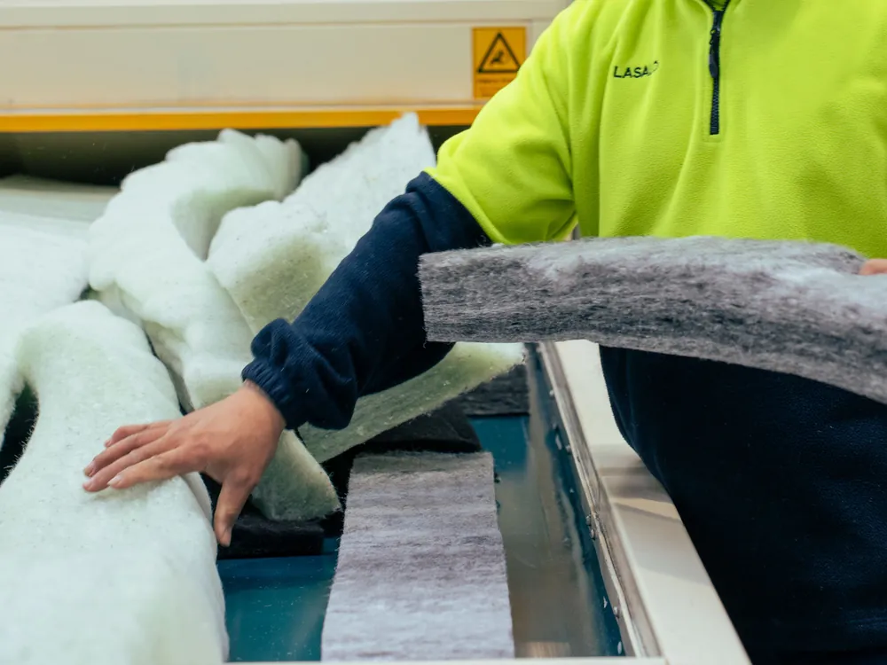 Autex worker inspecting returned polyester insulation offcuts on the Take Back Programme line.